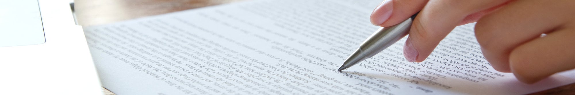 A close-up view of a hand holding a pen, underlining text in a scientific document related to the study of celestial bodies and phenomena.